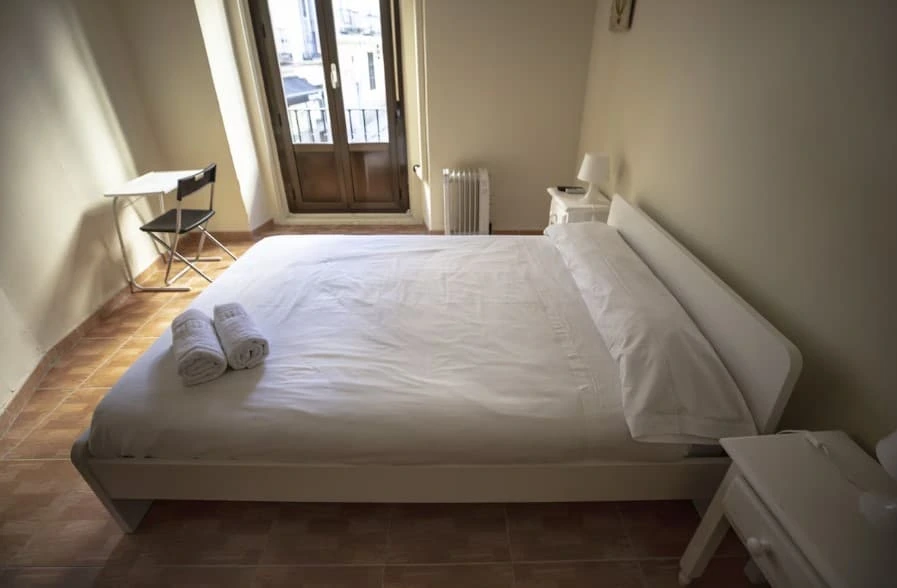 Double bed with towels facing the balcony door